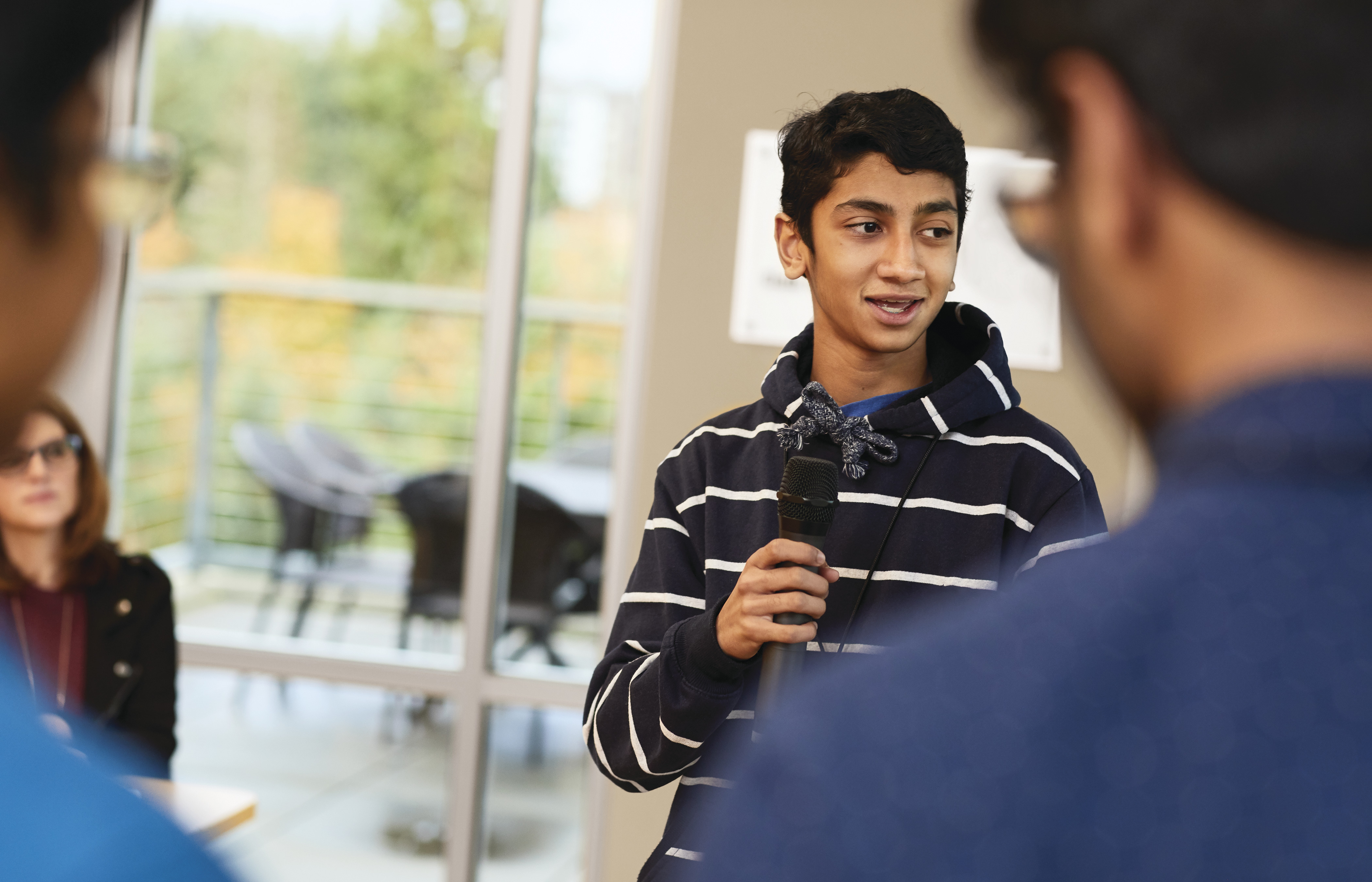 Teen in a hoodie speaking in a microphone Teen in a hoodie speaking in a microphone