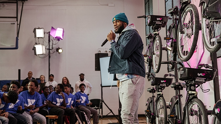 LeBron James speaking on stage in front of bicycles