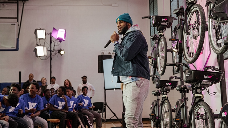 LeBron James speaking on stage in front of bicycles