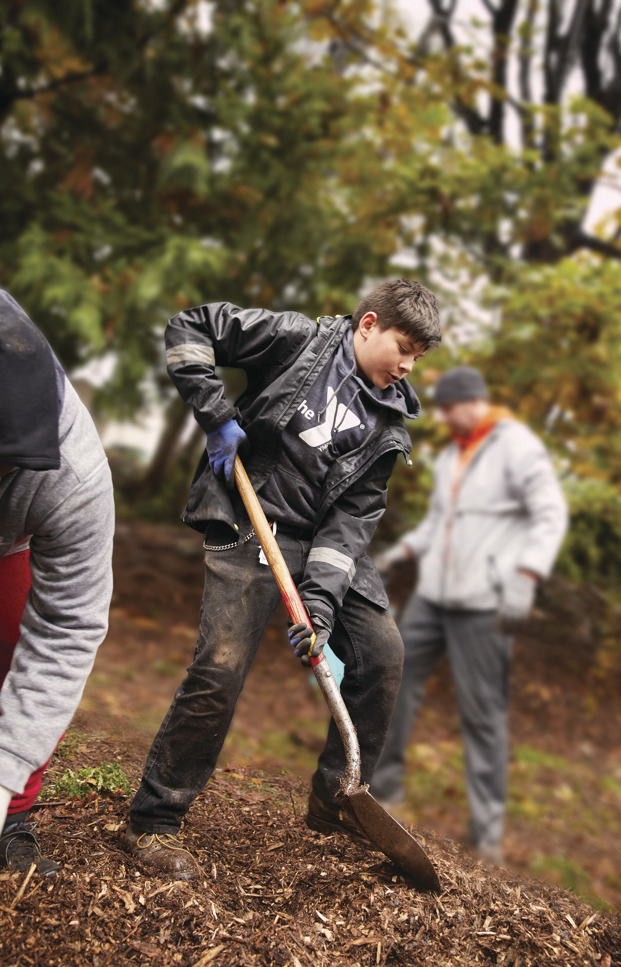 YMCA youth volunteers outside shoveling mulch YMCA youth volunteers outside shoveling mulch