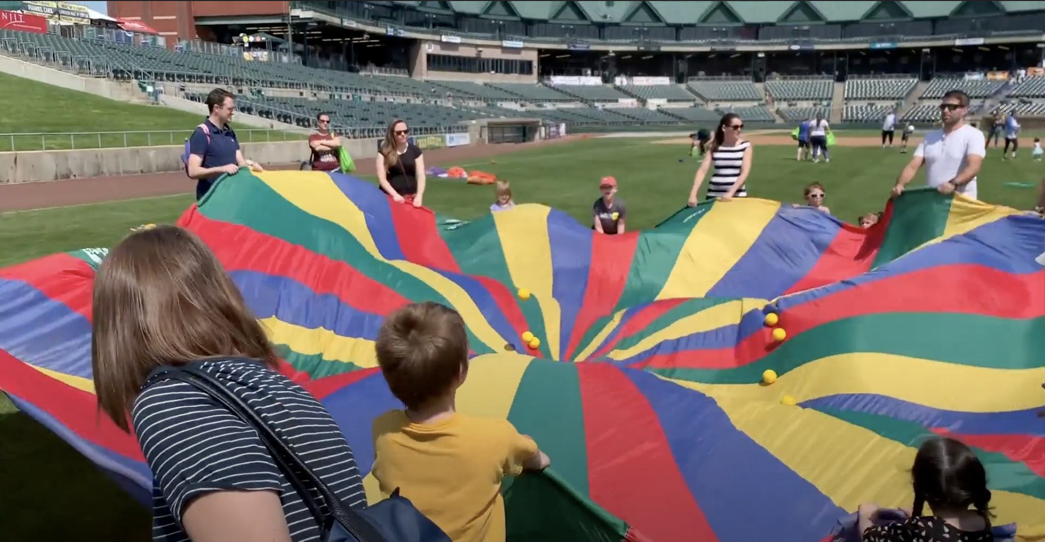 Youth in stadium playing with parachute 