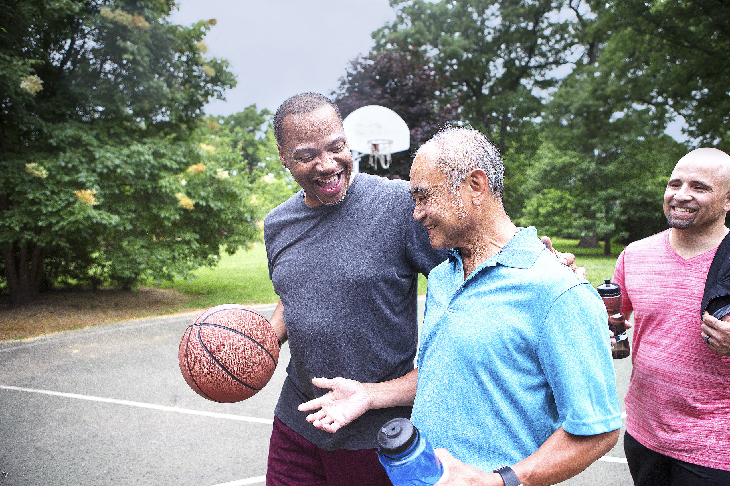 Men on basketball court laughing