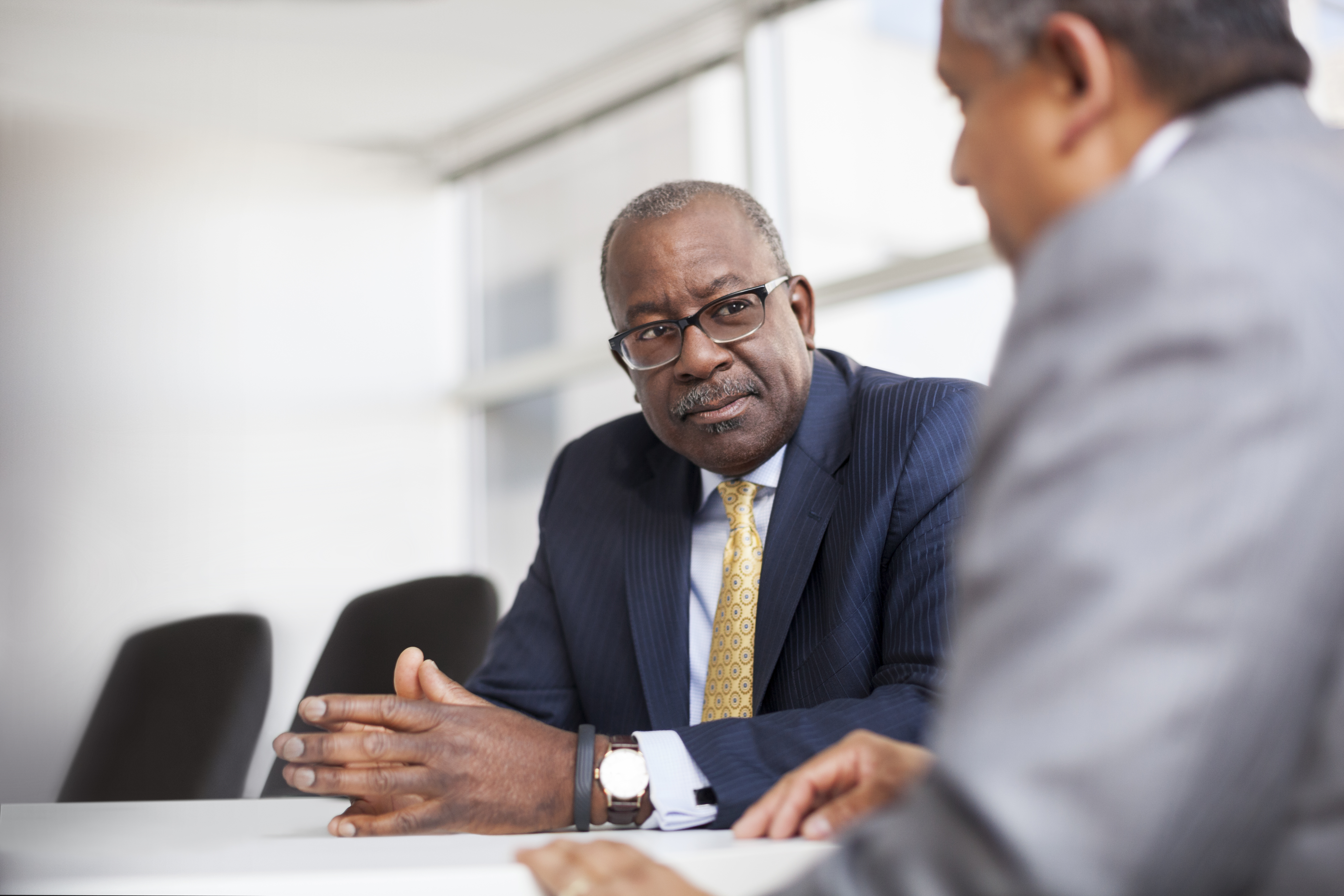Kevin Washington sitting in boardroom speaking to a man