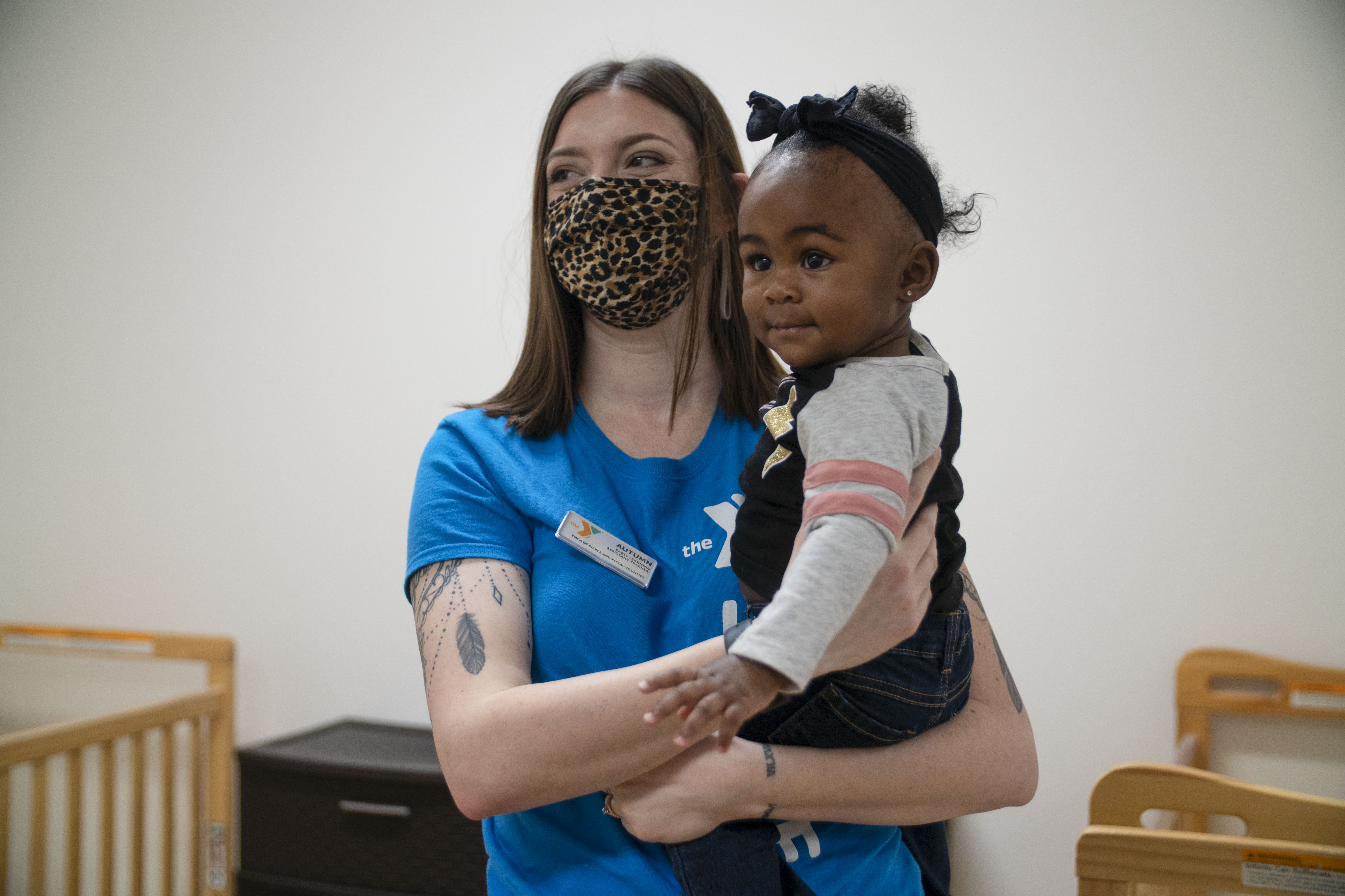 Staff member holding toddler in nursery 