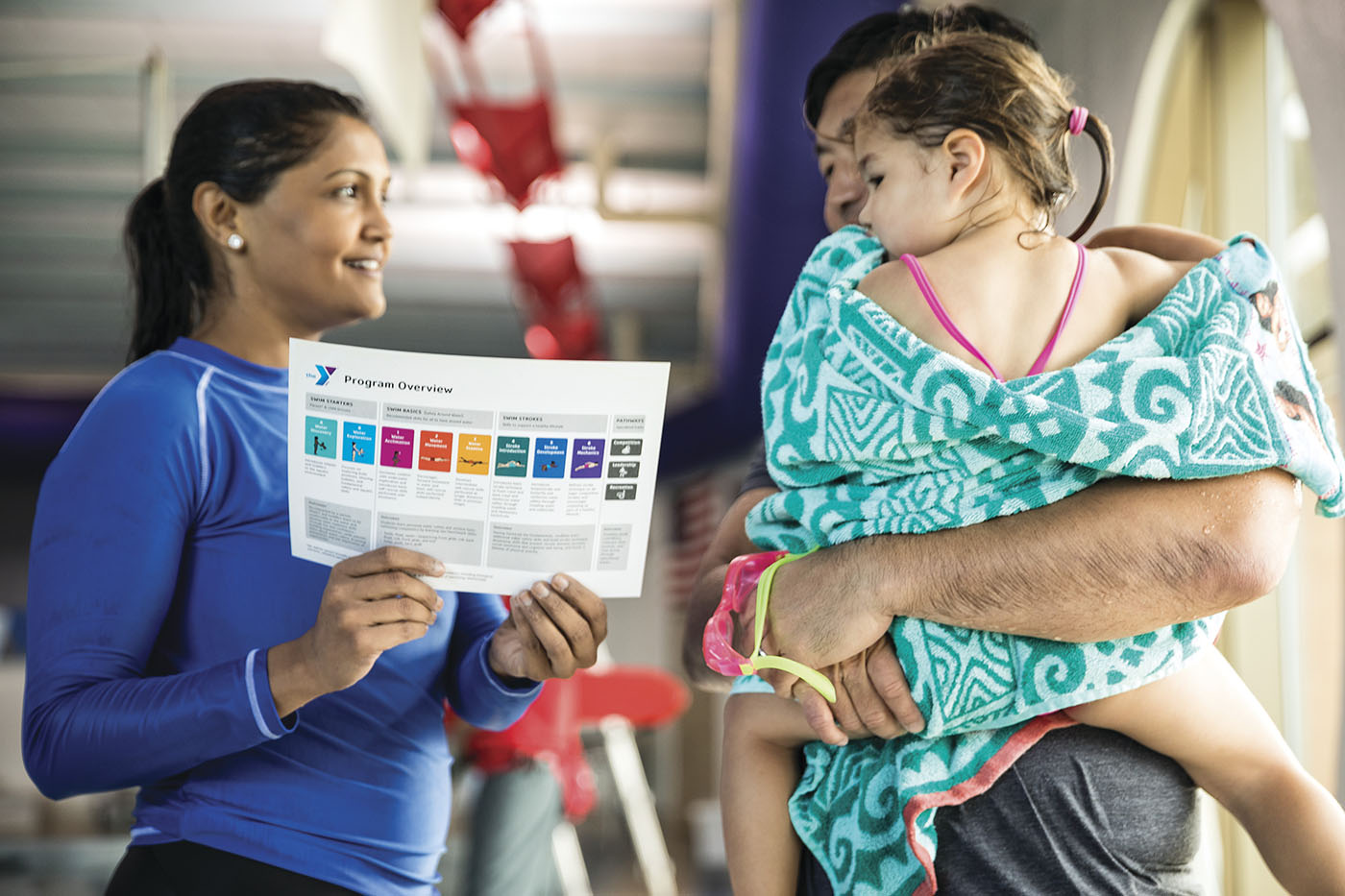 YMCA swim instructor talking to parent and child