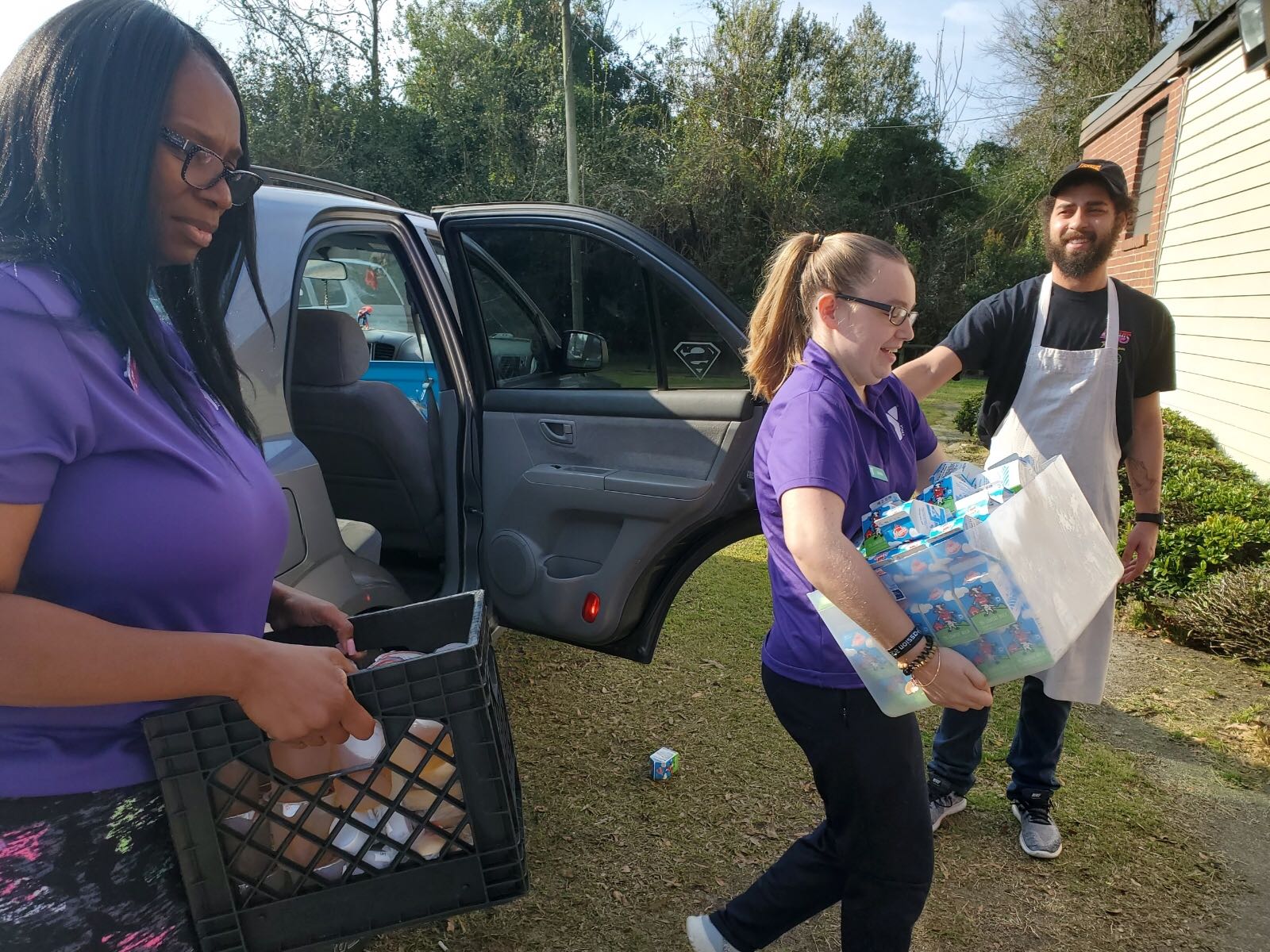 YMCA volunteers unload a car full of supplies for relief efforts