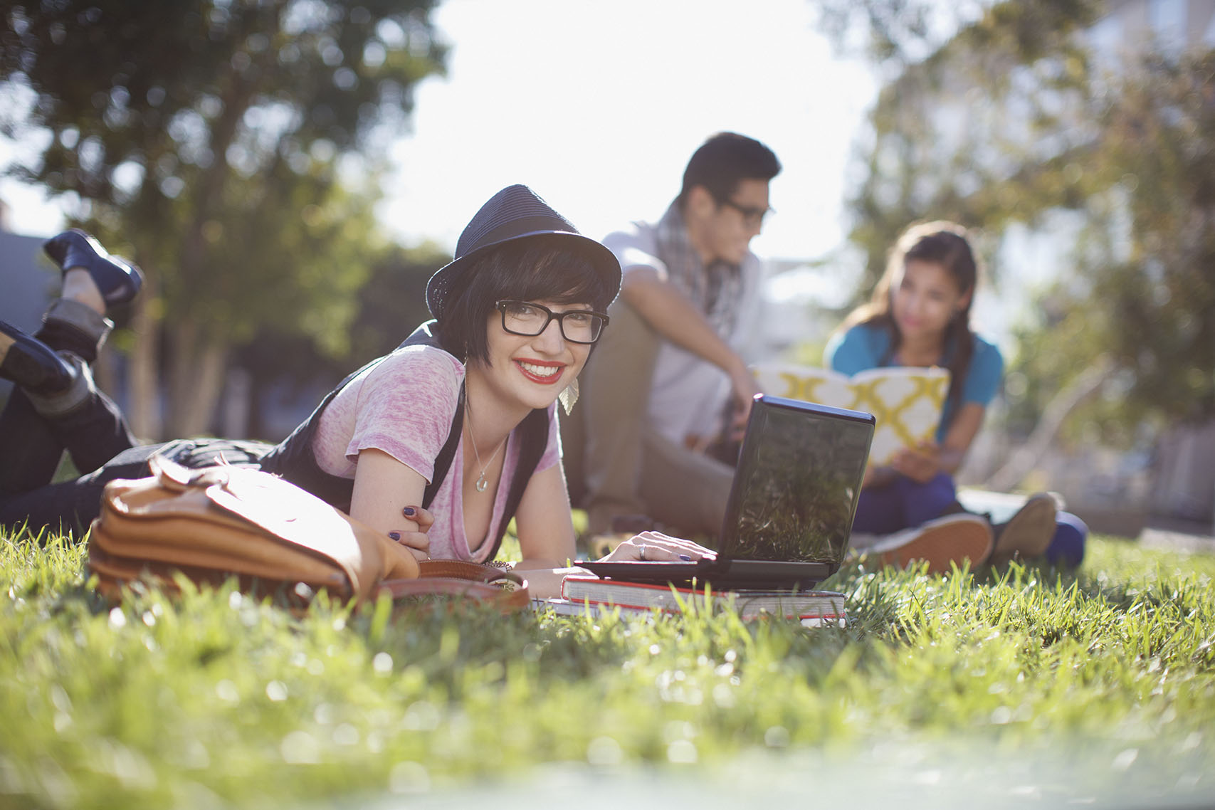 college students sitting outdoors doing homework