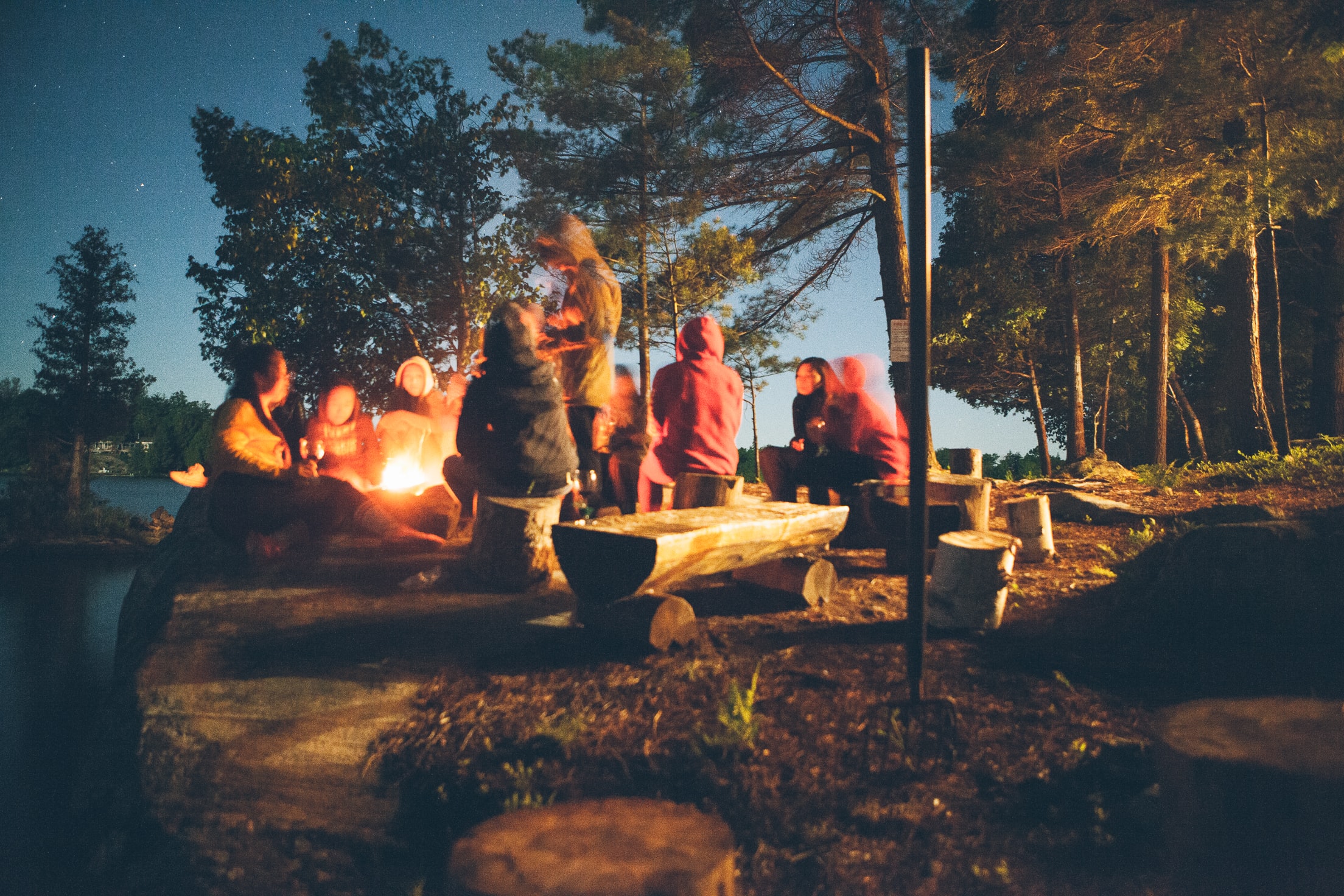 Group sitting around campfire at night