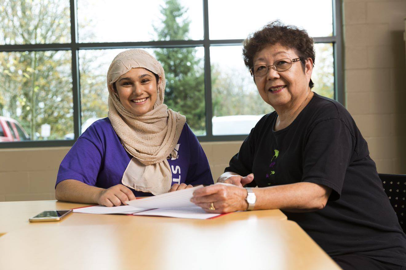 Women sitting at table going over paperwork - YMCA