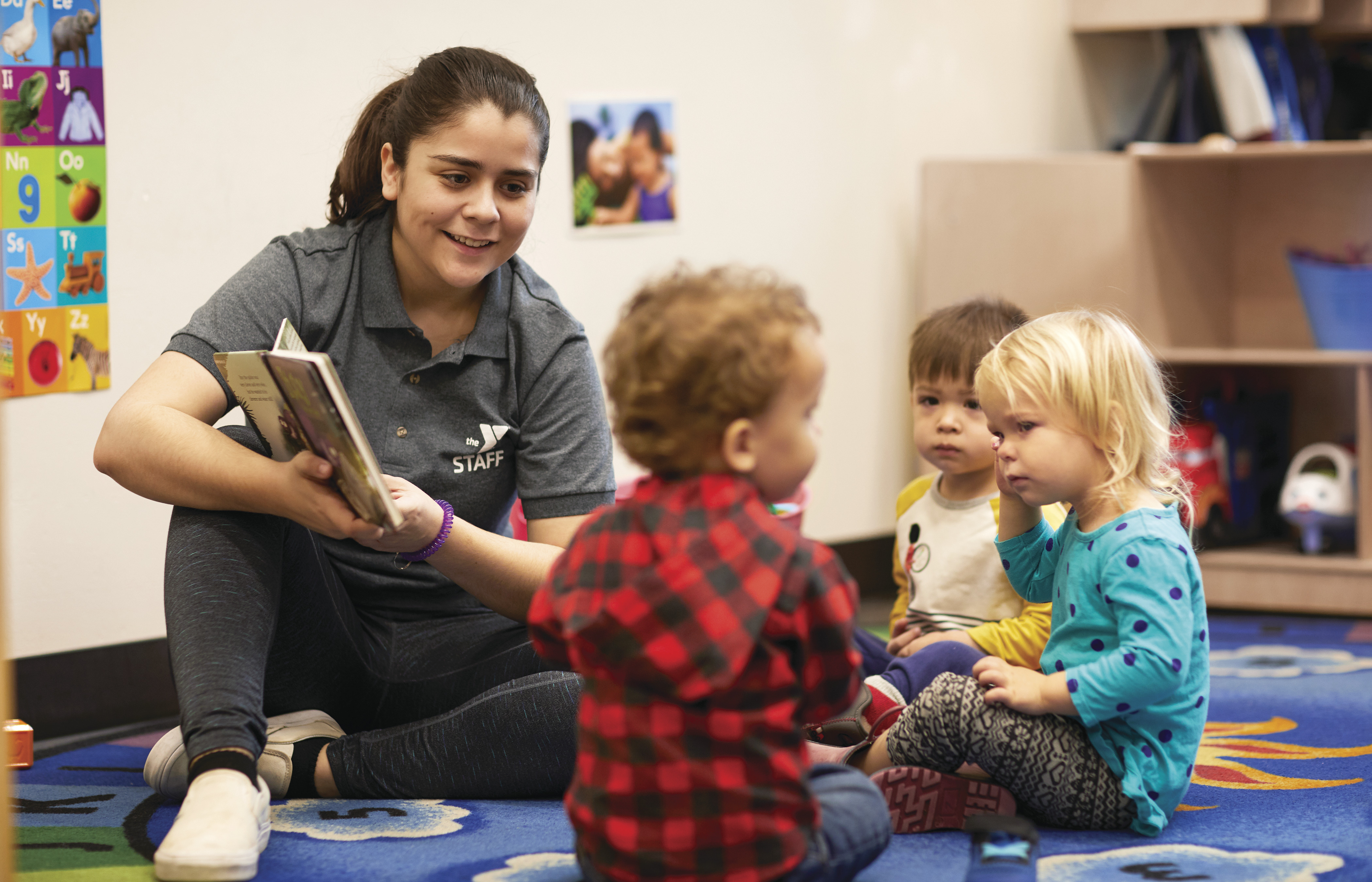 Child Care Learning Programs: YMCA daycare worker reading to toddlers  Child Care Learning Programs: YMCA daycare worker reading to toddlers