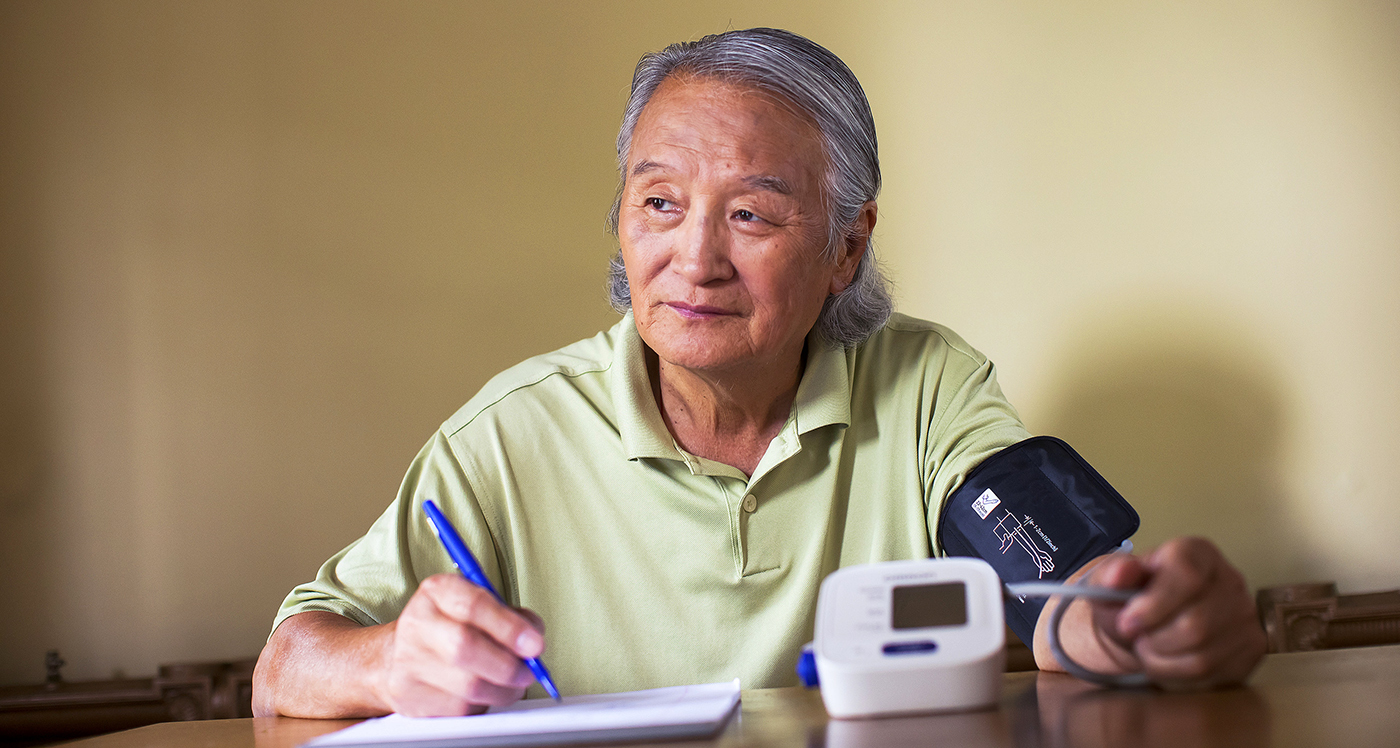 Man sitting at table taking diabetes test - YMCA Man sitting at table taking diabetes test - YMCA