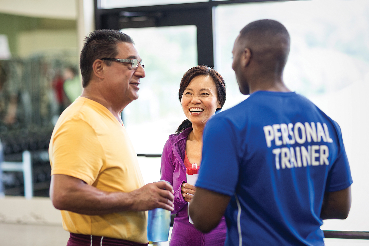 Adult members talking to YMCA personal trainer