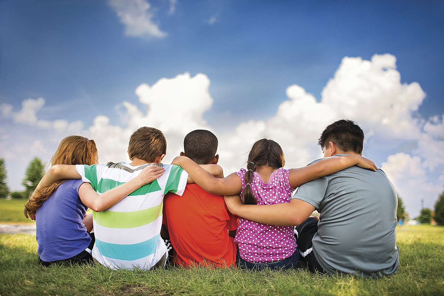 YMCA members sit in field and watch sky