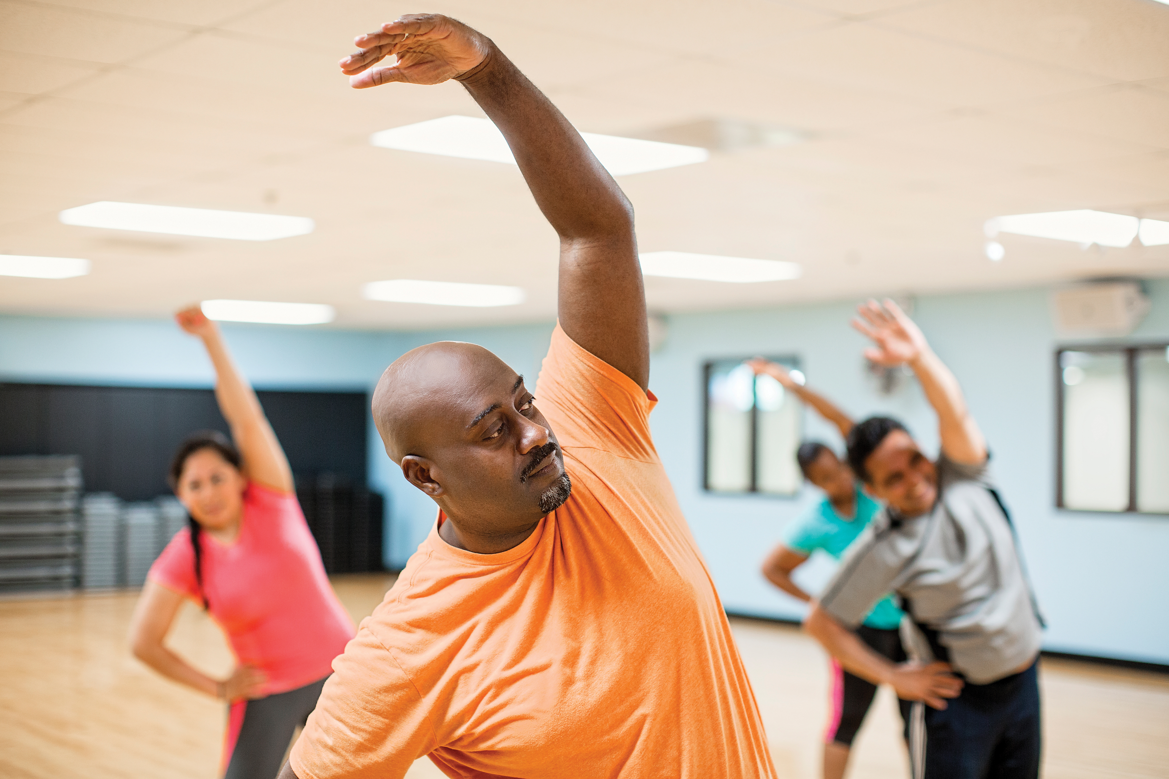 Adults stretching in group fitness class