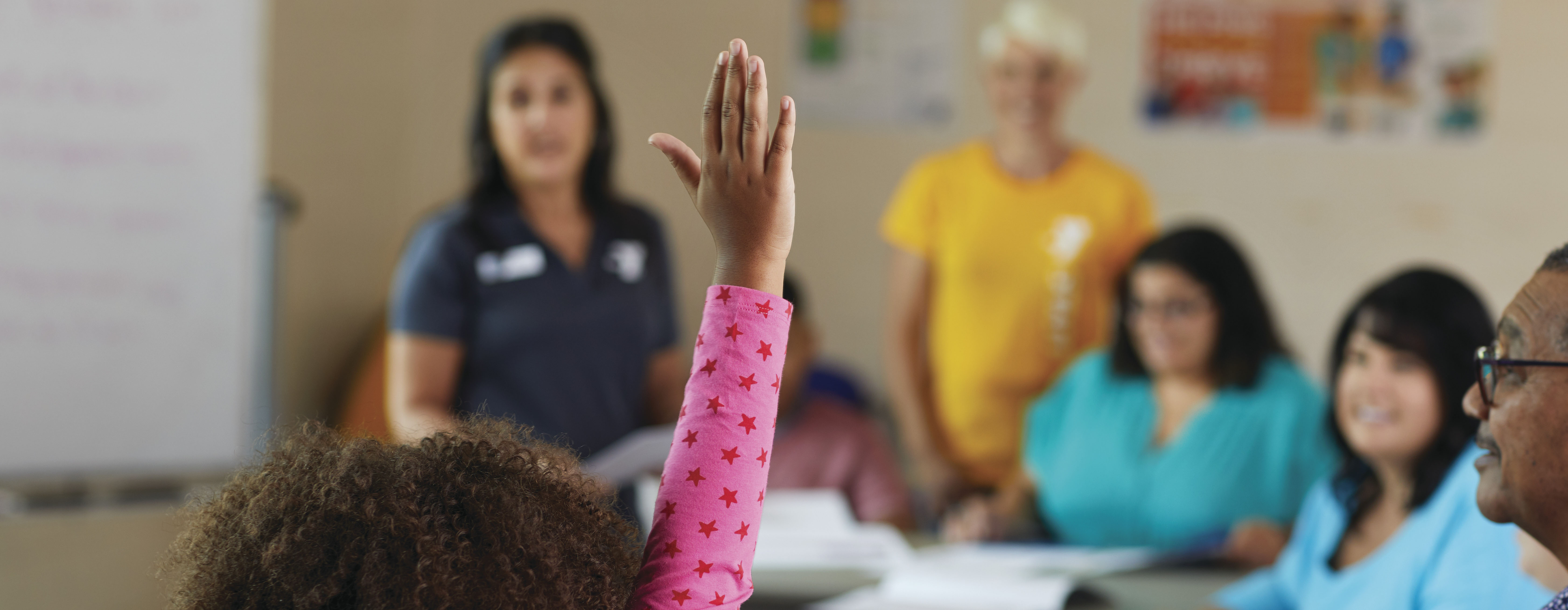 Child raising hand in classroom Child raising hand in classroom