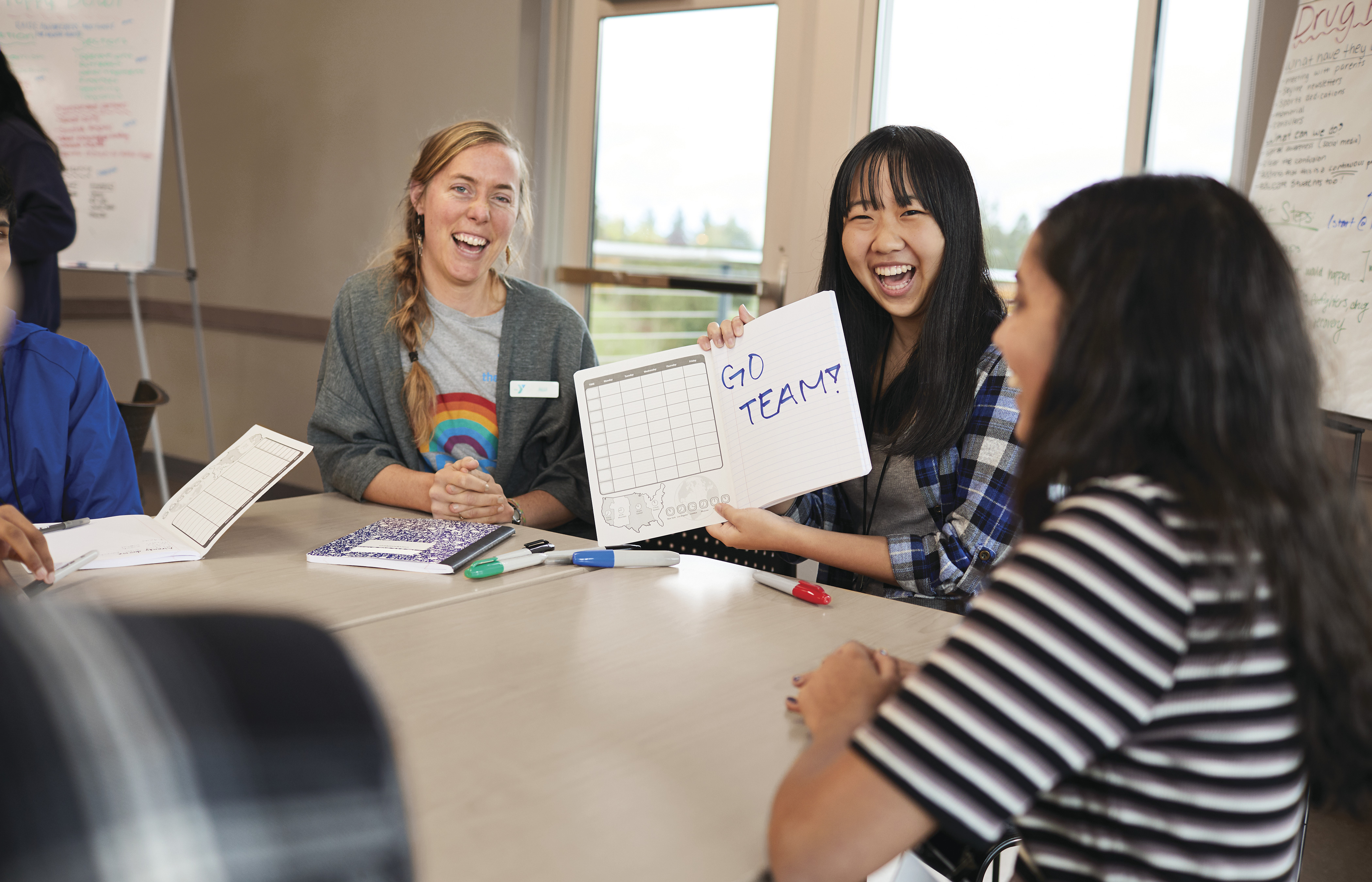 Teens sitting around table in meeting room at YMCA