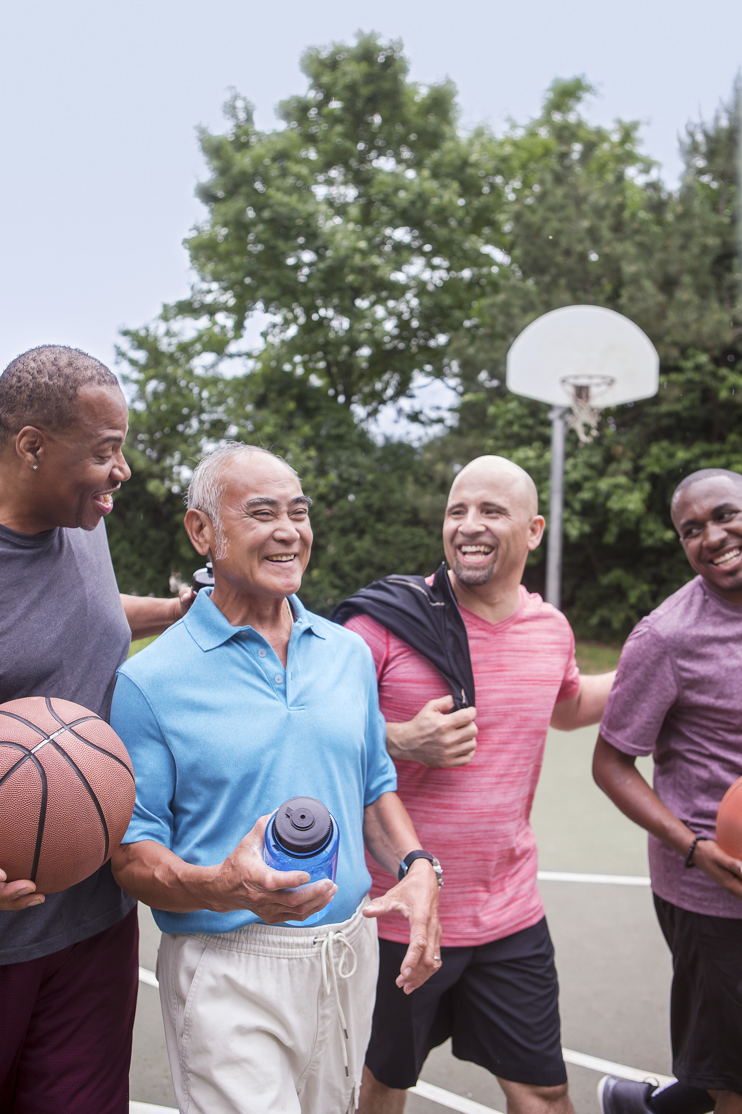 Group of men chatting on the outdoor basketball court Group of men chatting on the outdoor basketball court