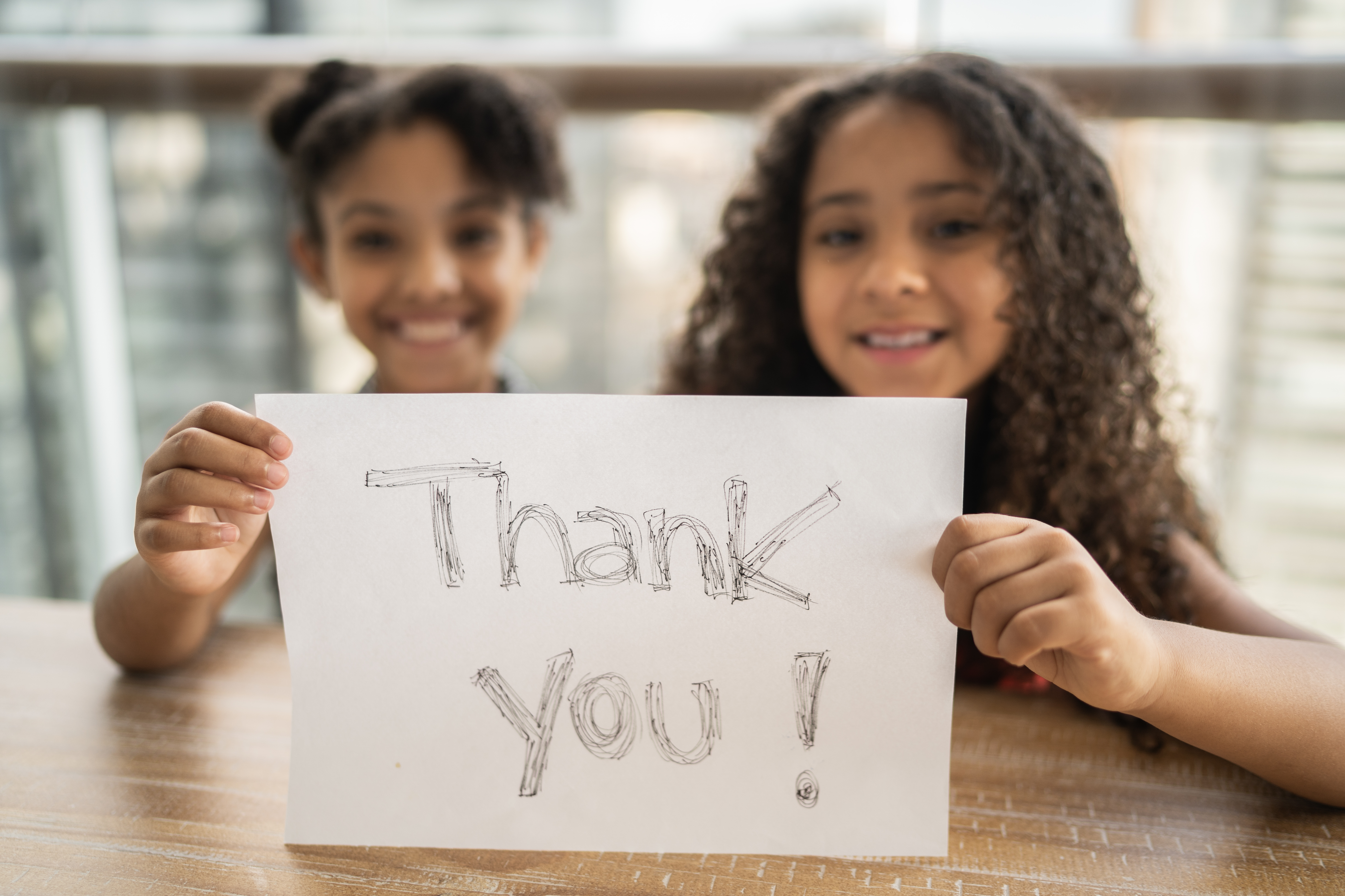 Two young YMCA members holding Thank You sign