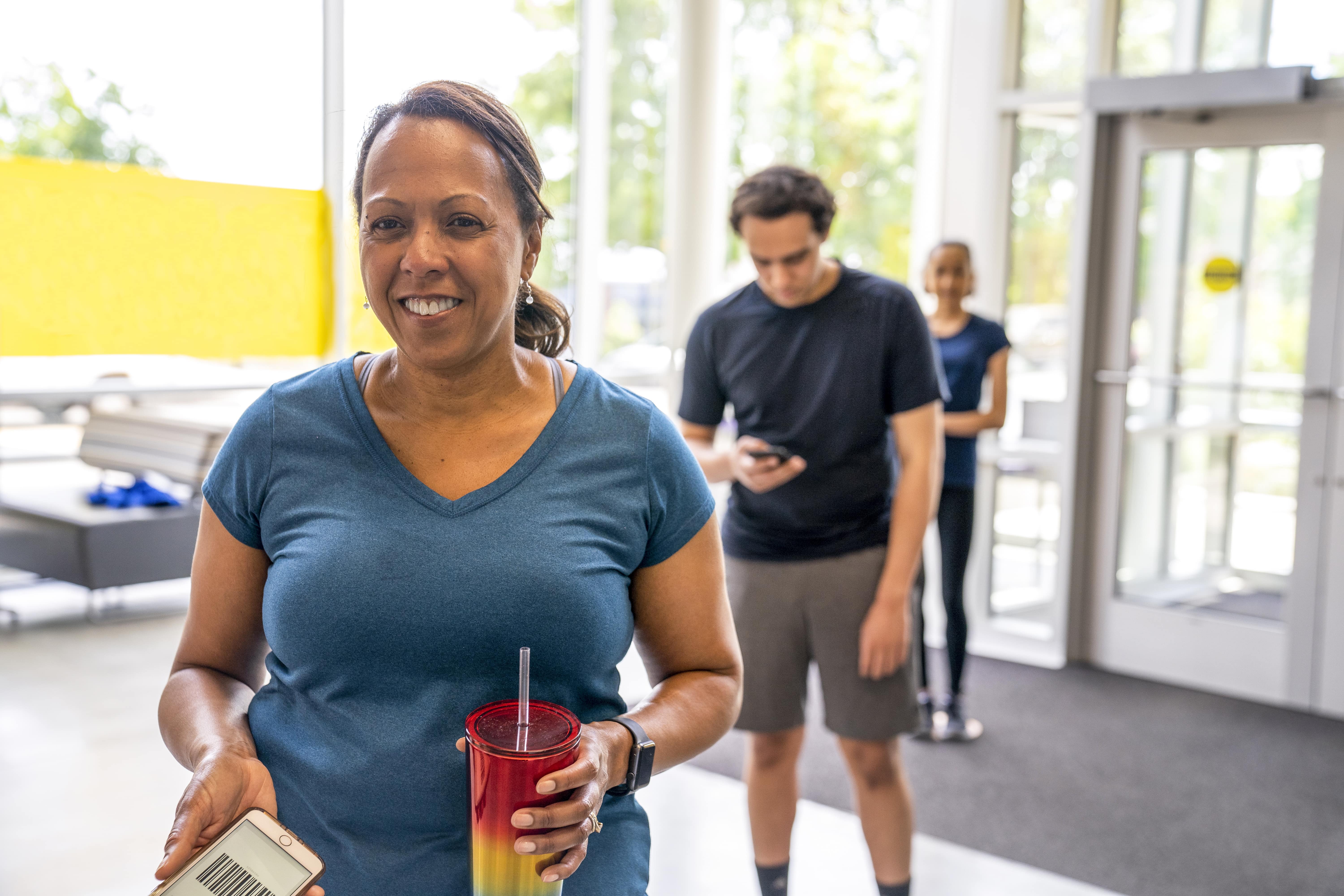 Woman holding plastic drink cup in line Woman holding plastic drink cup in line
