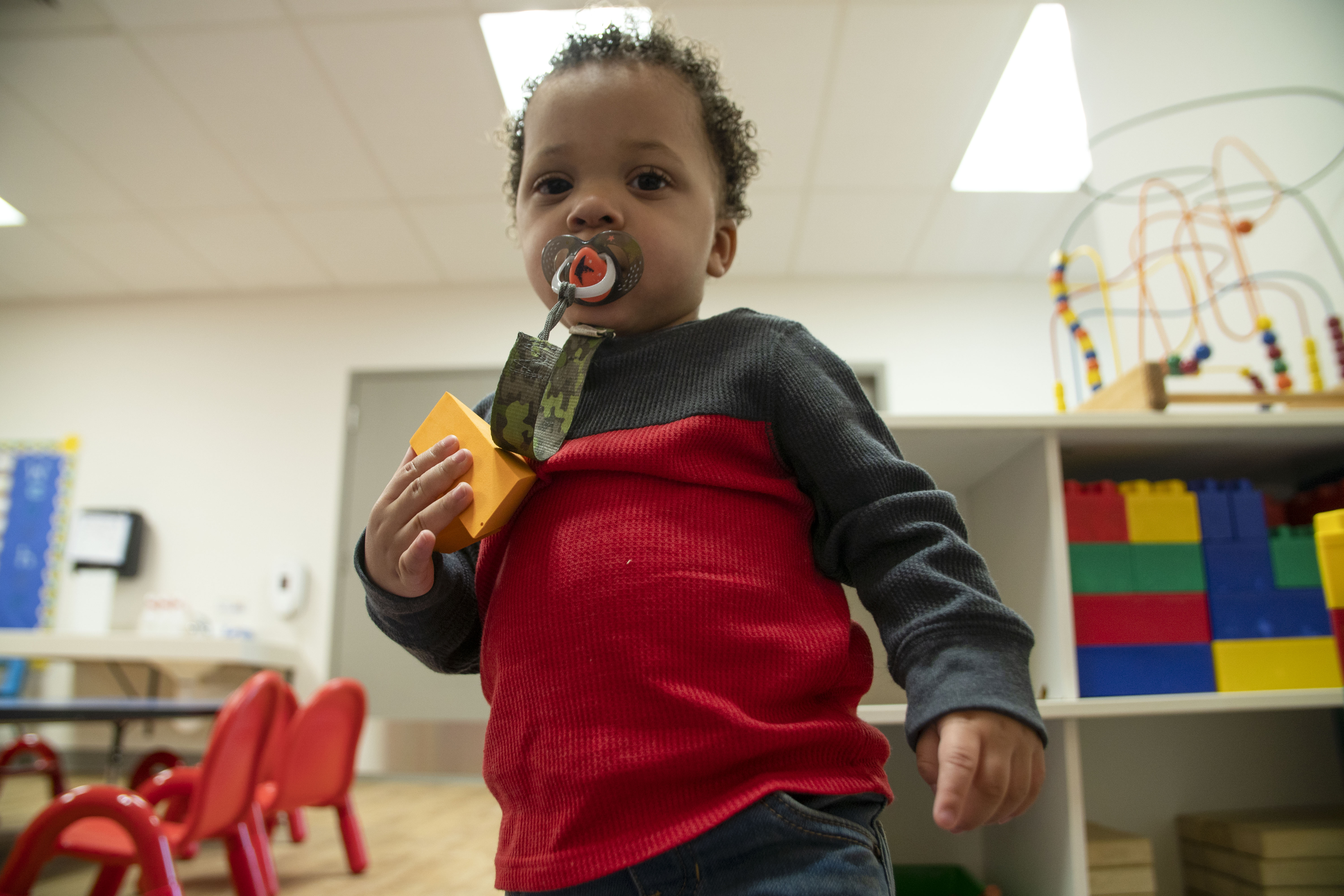 Toddler in playroom at YMCA playing with toys Toddler in playroom at YMCA playing with toys