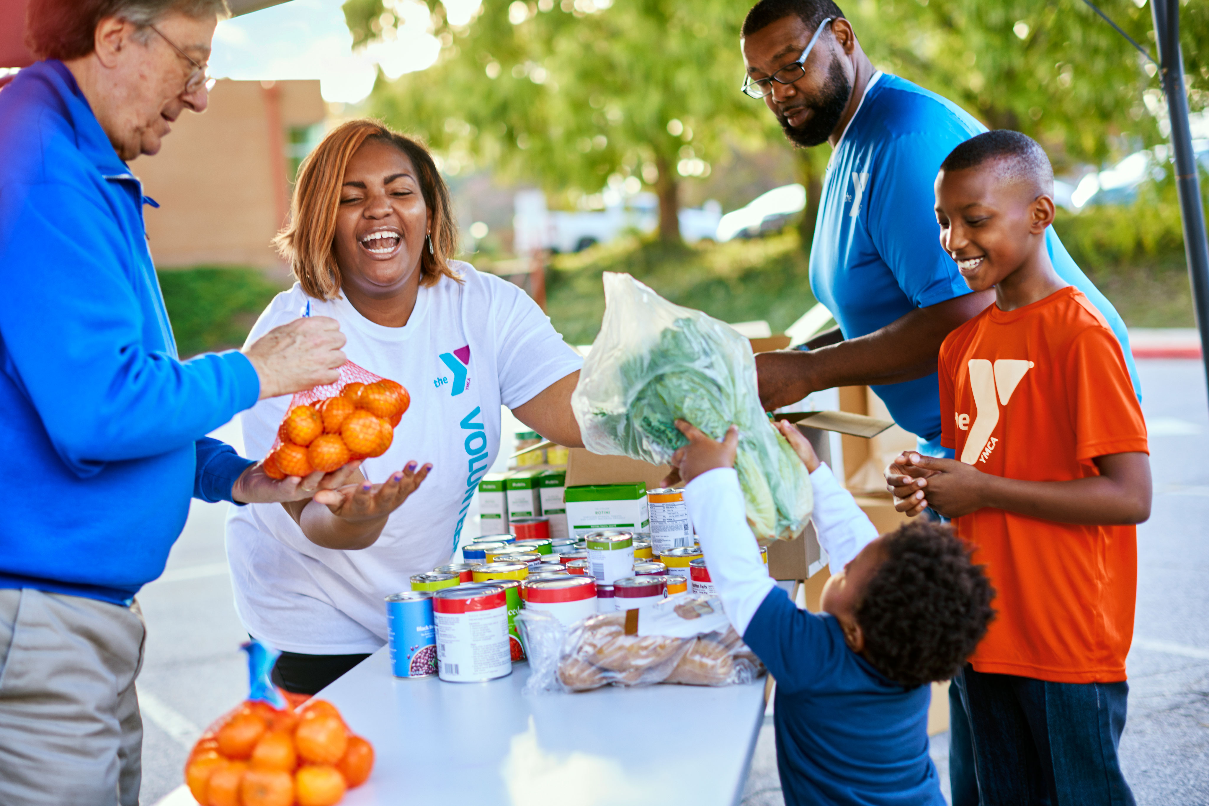 Volunteer family handling fresh produce for Y food drive Volunteer family handling fresh produce for Y food drive