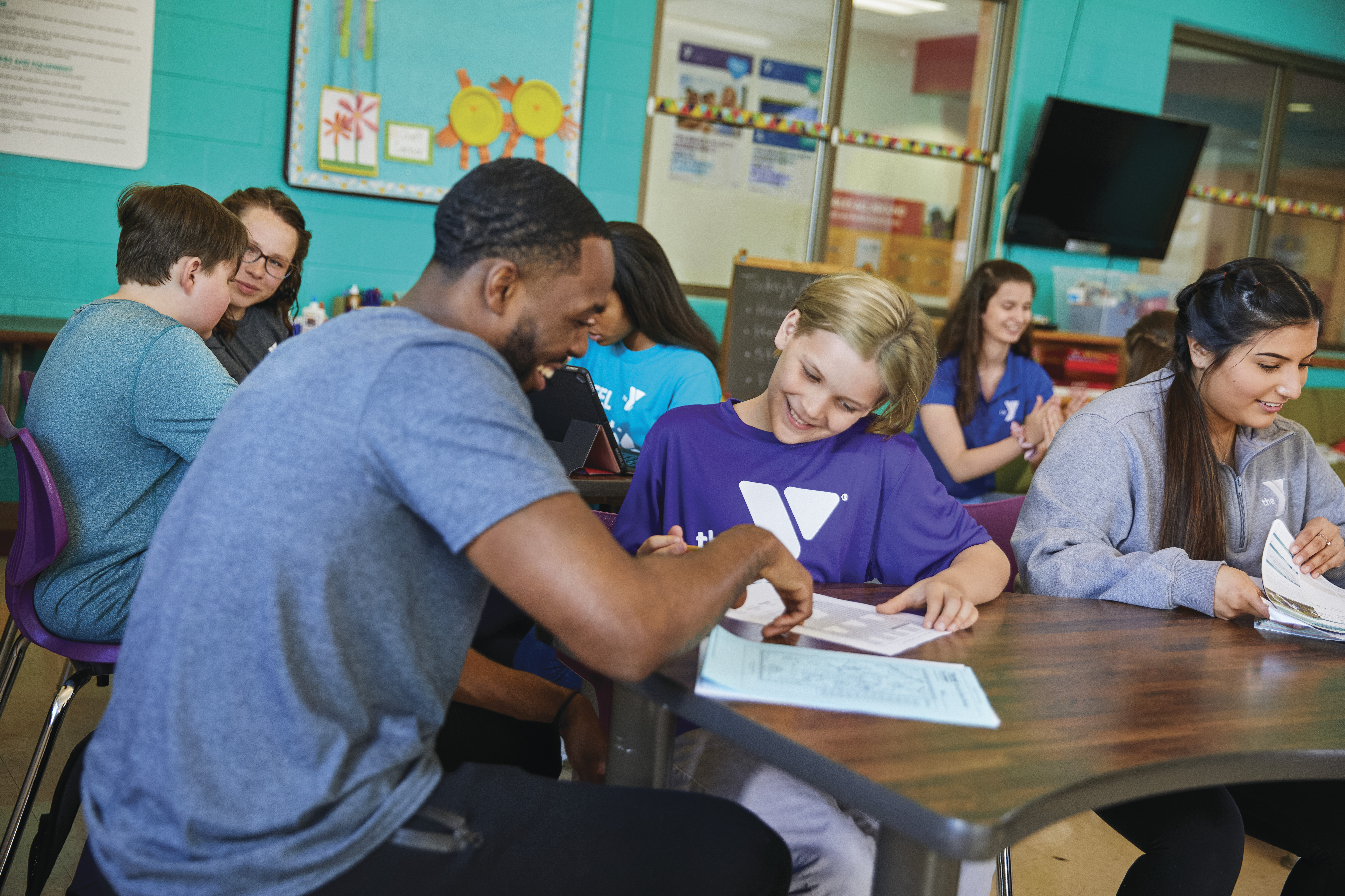 YMCA staff helping boy with homework YMCA staff helping boy with homework