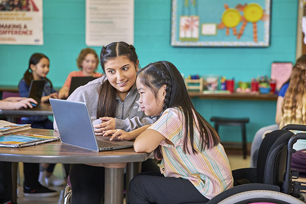 Two girls on computer in The AchieverySM partnership with the Y.
