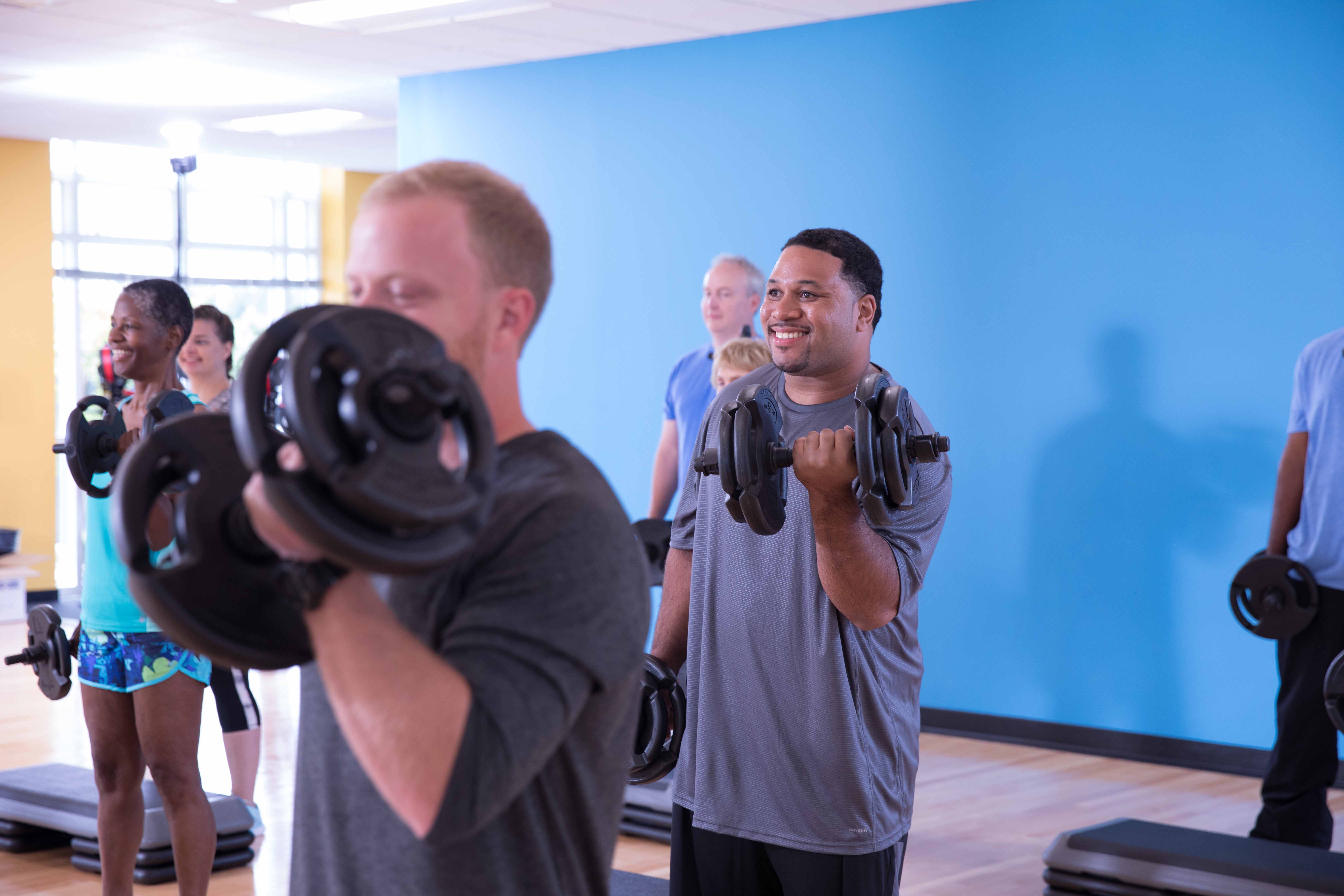 Man lifting weights at YMCA class Man lifting weights at YMCA class