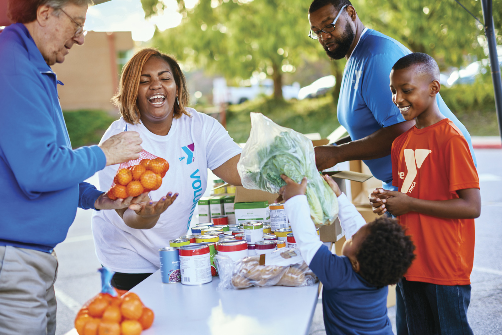 A YMCA volunteer smiles at a food drive