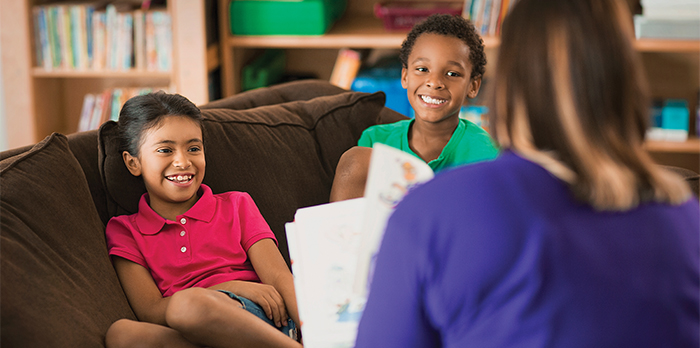 Adult reading a book to children