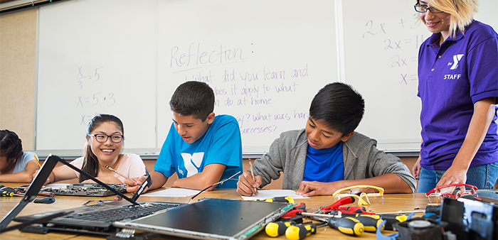 Two boys writing, working with computers