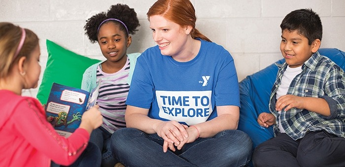 Child reading to adult and other children