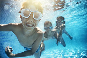 Kids swimming in pool with goggles