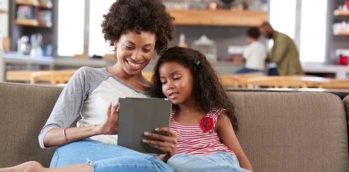 Parent and child looking at a tablet on the couch