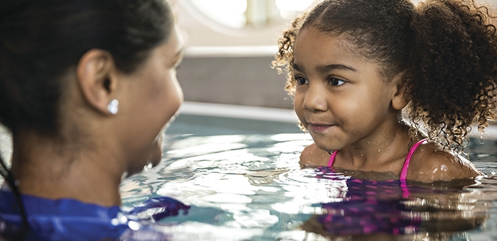 Adult and child swimming together