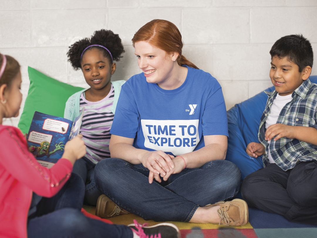 Adult reading a book with kids