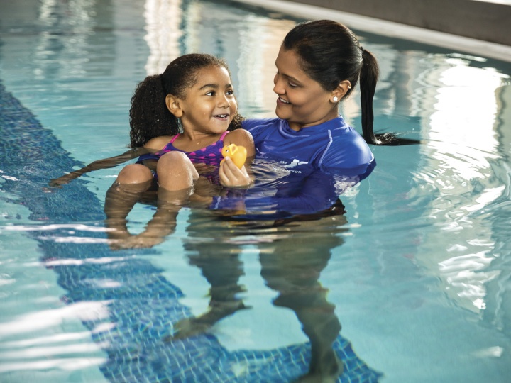 YMCA swim instructor in pool with girl toddler