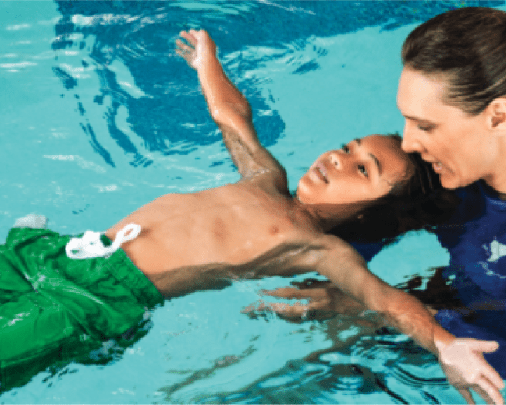 Child learning to swim in a pool Child learning to swim in a pool