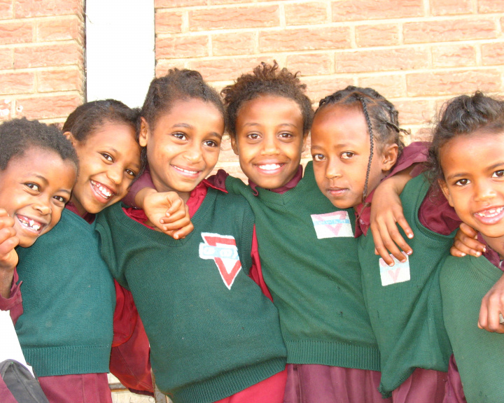 Smiling children with their arms around each other
