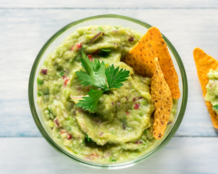 Greek yogurt guacamole and chips in a bowl Greek yogurt guacamole and chips in a bowl
