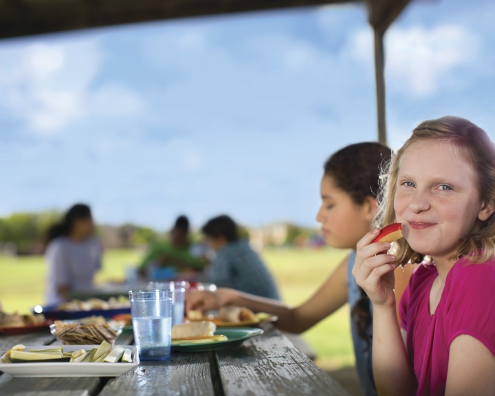 Children eating outdoors at picnic table