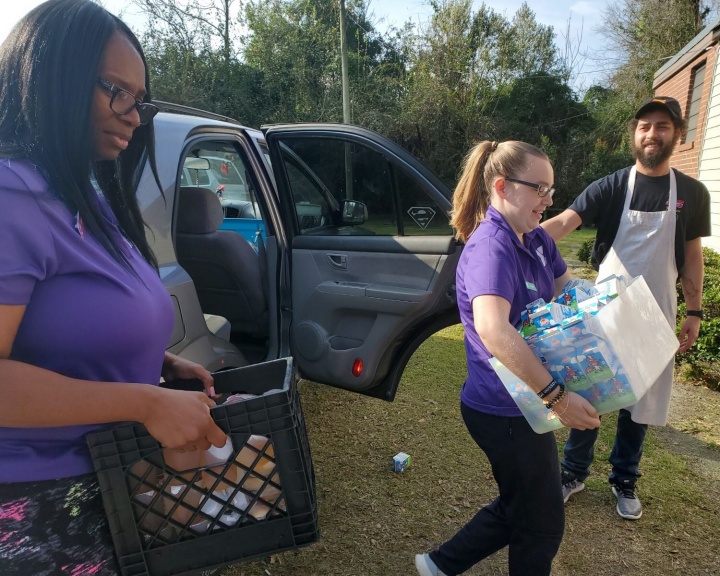YMCA volunteers unload a car full of supplies for relief efforts