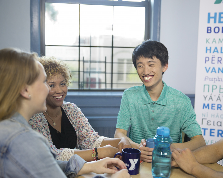 Group of adults sitting around a table smiling Group of adults sitting around a table smiling