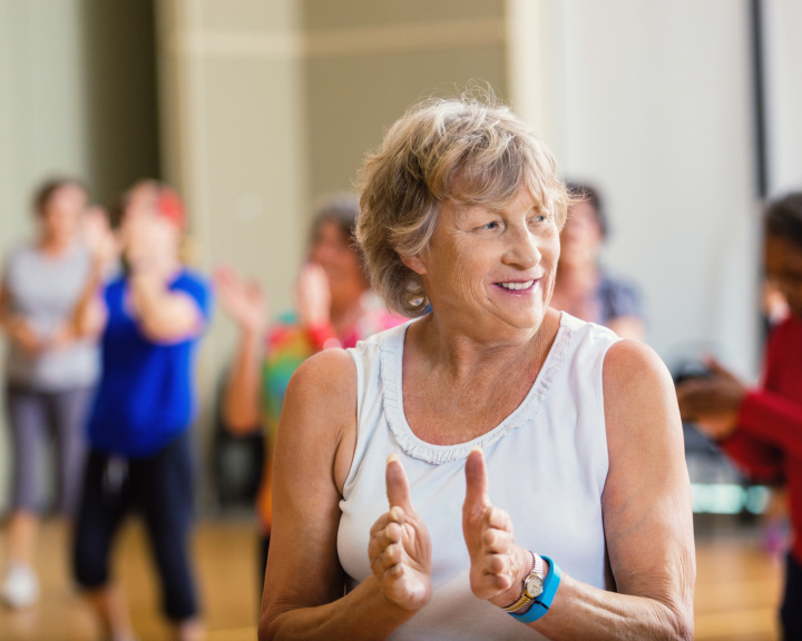 Woman in a group fitness class with others behind her. Woman in a group fitness class with others behind her.