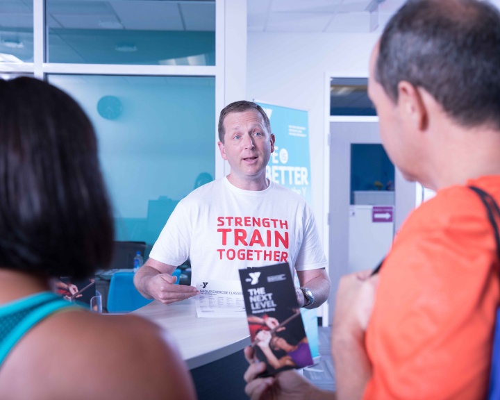 Trainer at YMCA talking to members Trainer at YMCA talking to members