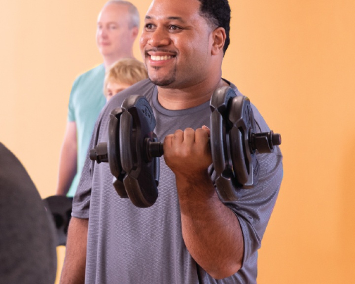 Man lifting weights at YMCA class Man lifting weights at YMCA class