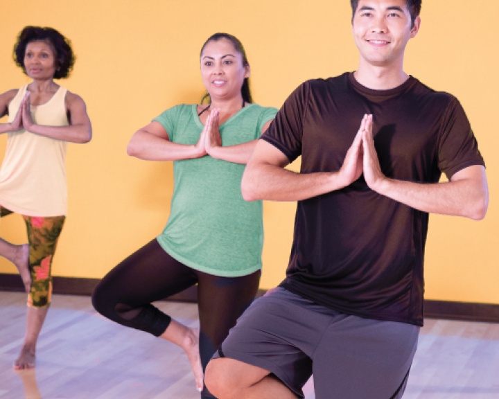 People standing doing yoga in a class
