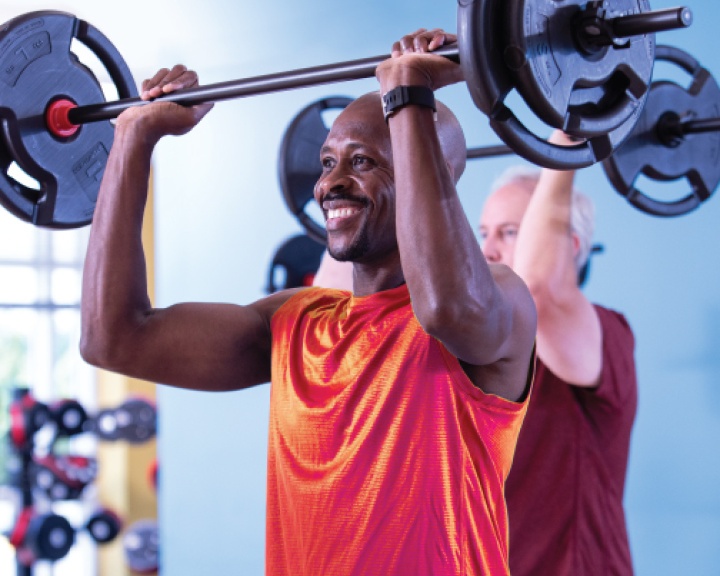 Man lifting barbell in fitness class