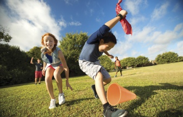 Kid beats another kid to grabbing a red bandana on a field