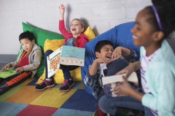 Children laughing while reading in playroom at YMCA